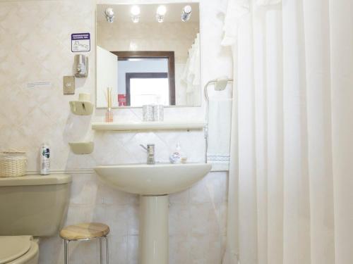 La salle de bains est pourvue d'un lavabo, de toilettes et d'un miroir. dans l'établissement Sandy Point B&B, à Punta Arenas