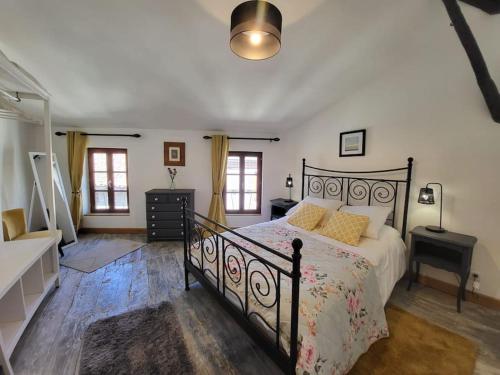 um quarto com uma cama preta e almofadas amarelas em Lovingly renovated 3 bedroom townhouse em Rochechouart