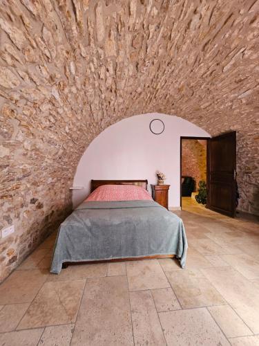 een slaapkamer met een bed in een stenen muur bij Gite 5 personnes SOLOGNE in Hargeville