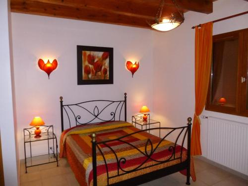 a bedroom with a bed and two lamps on the wall at Ferme Auberge du Bessard in Allevard