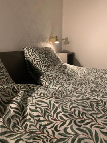 a bed with a black and white comforter and pillows at Stockholm Archipelago House with shared pool in Mörtviken