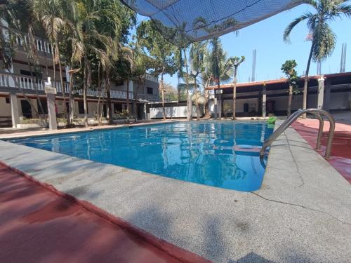 una piscina en un hotel con palmeras en Olas de Sol en La Libertad