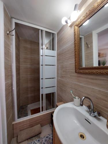 une salle de bain avec un lavabo et un miroir dans l'établissement Hyères studio refait à neuf dans la cité médiévale, à Hyères