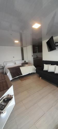 Habitación grande con cama y sofá en Suite Gold Rocks Glamping en El Peñol