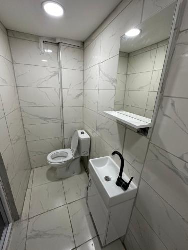 een badkamer met een toilet, een wastafel en een spiegel bij URAZ Apart in Bursa