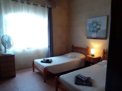 艾因西萊姆的住宿－Bed and Breakfast Dar Tal-Lumija，一间卧室设有两张床和窗户。