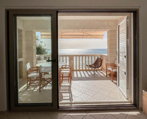 une porte coulissante en verre menant à une terrasse avec une table et des chaises. dans l'établissement Apartment Radovic, à Sveti Stefan