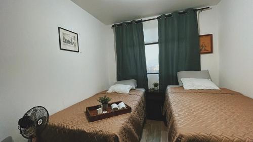 a bedroom with two beds and a window at Apartamento en centro Ciudad de Guatemala z12 in Guatemala