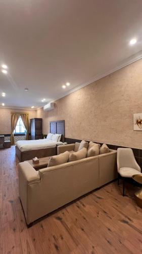 a large living room with a couch and a bed at سيبار للشقق المخدومة Sippar Serviced Apartments in Hotat bani tamim
