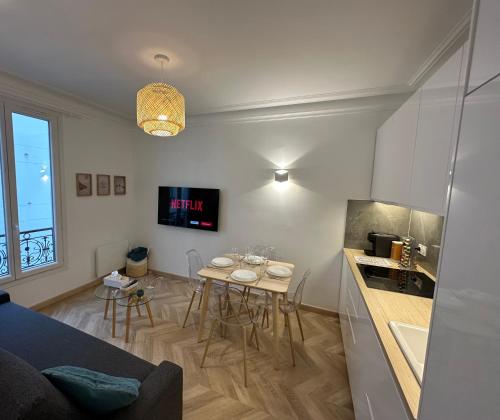 - un salon avec une cuisine et une table avec des chaises dans l'établissement PARIS-ALESIA Super appartement 2 pièces de 39m2 - très cosy pour 1 - 5 personnes totalement refait à NEUF -ENTIRE APARTMENT LUXURIOUS AND WARM -PARIS ALESIA 14ème - Proche Aéroport Paris-Orly - Parc des Expositions Porte de Versailles FREE WIFI GRATUIT, à Paris