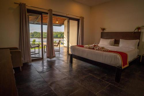 a bedroom with a bed and a view of the water at Dandeli Kali River Stay in Dandeli
