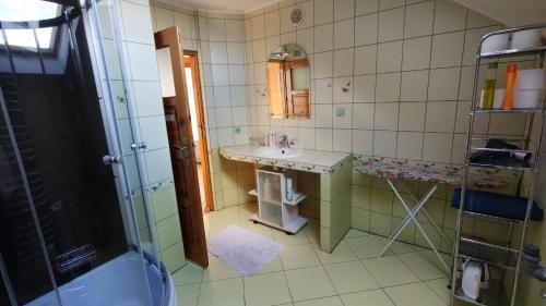 a bathroom with a sink and a mirror at Chess Apartament in Augustów