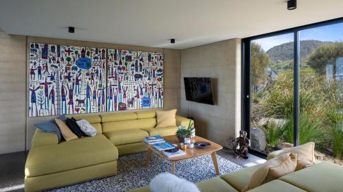 a living room with a yellow couch and a table at Little Beach Resort in Four Mile Creek