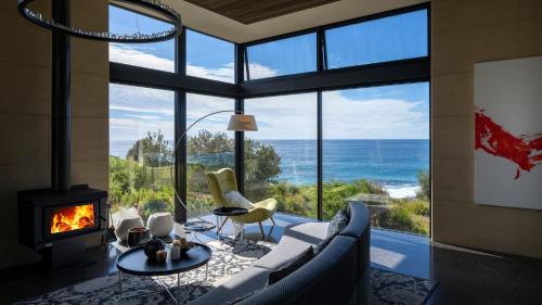 sala de estar con chimenea y vistas al océano en Little Beach Resort en Four Mile Creek