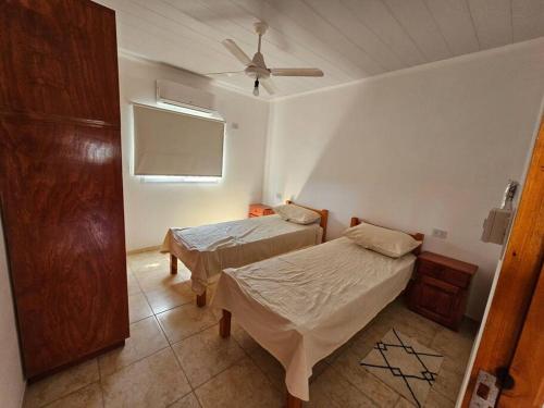 een slaapkamer met 2 bedden en een plafondventilator bij Casa quinta Gabi in San José del Rincón