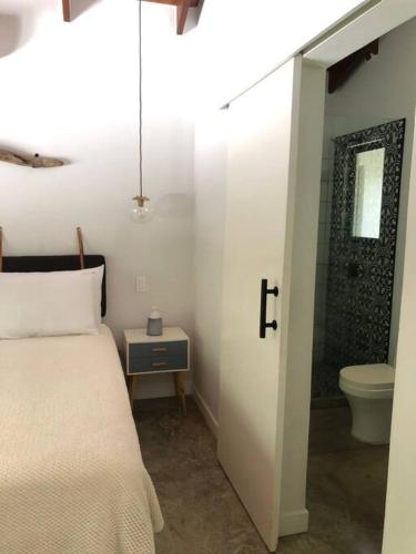 a bedroom with a bed and a bathroom with a toilet at Casa Anna, Private Home, Guiones in Nosara