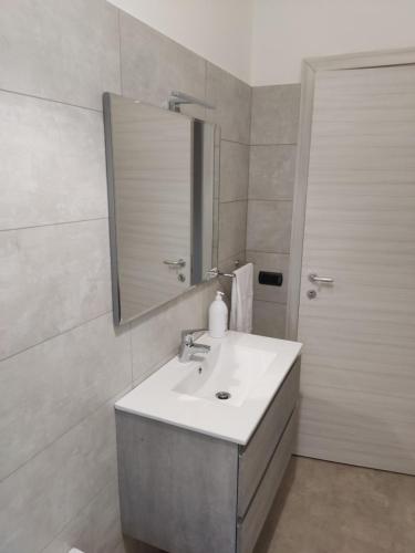 y baño con lavabo y espejo. en Sunrise Apartment Marina Beach, en Marina di Gioiosa Ionica