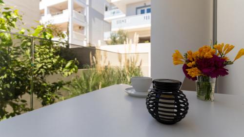 a black vase sitting on a table with flowers at Vakakis Family Luxury Studios in Palaiochóra