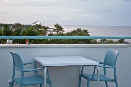 a table and chairs on a balcony with the beach at B&B Alalama in Polignano a Mare