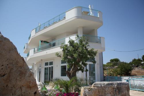 Casa blanca con balcón en la parte superior. en B&B Alalama, en Polignano a Mare