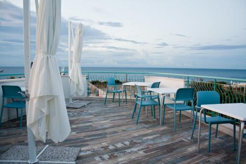 a patio with tables and chairs and the ocean at B&B Alalama in Polignano a Mare