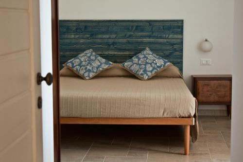 a bedroom with a bed with blue pillows on it at B&B Alalama in Polignano a Mare