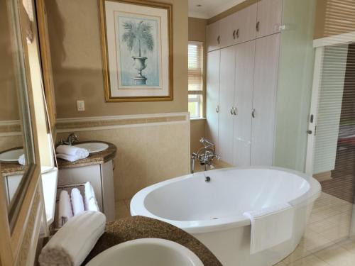 a bathroom with a large tub and a sink at Villa Penthouse 17-5 in Mossel Bay