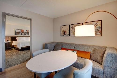 a living room with a couch and a table and a bed at Hilton Garden Inn Terre Haute in Terre Haute