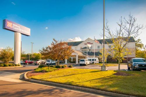 a building with a sign in a parking lot at Hilton Garden Inn Jackson/Pearl in Pearl