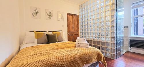 a bedroom with a bed and a glass wall at Luxury 3 Bed Apt in Camden in London