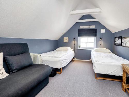a room with three beds and a couch at 5 person holiday home in Løkken-By Traum in Løkken