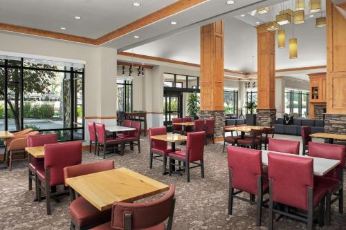 a restaurant with tables and chairs and windows at Hilton Garden Inn Missoula in Missoula