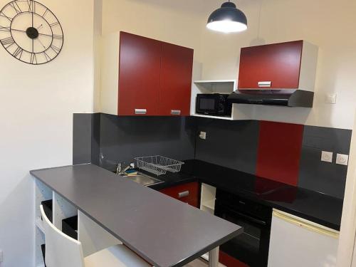 une cuisine avec une table et une horloge au mur dans l'établissement Roubaix centre bel appartement de type 2, à Roubaix