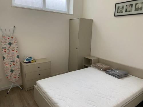 ein Schlafzimmer mit einem weißen Bett und einem Schrank in der Unterkunft Roubaix centre bel appartement de type 2 in Roubaix