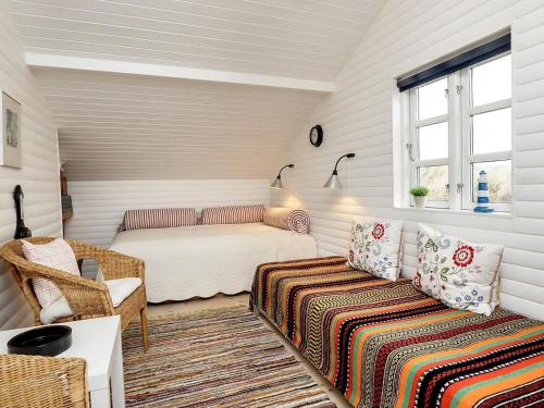 um quarto com uma cama e um sofá num quarto em Holiday home Brovst XI em Brovst