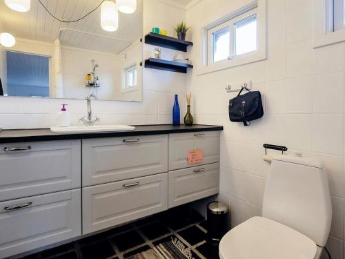 uma casa de banho com um lavatório branco e um WC. em Holiday home Brovst XI em Brovst