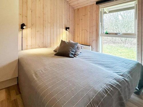 een slaapkamer met een groot bed en een raam bij Holiday Home Kronvildtvej IV in Brovst