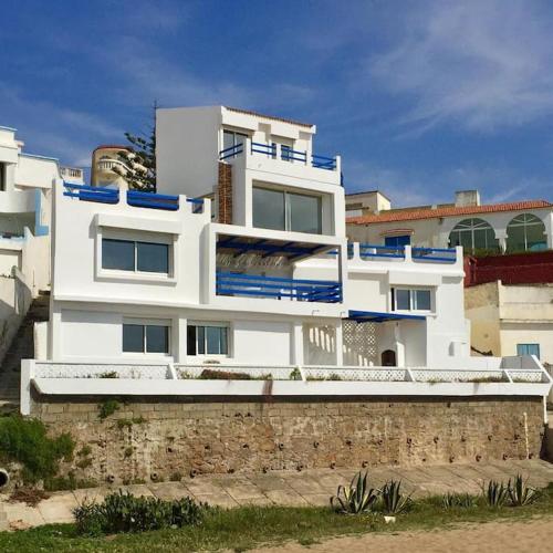 a large white building on top of a stone wall at Villa vue imprenable sur l’Océan. in Moulay Bousselham