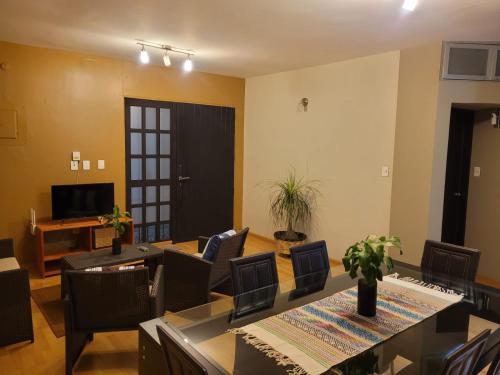 a living room with a table and chairs and a television at Casa B & L Céntrico Departamento in Oaxaca City