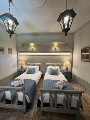 two beds in a room with two lamps at Casale San Giorgio in Luco di Mugello
