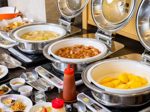 a buffet with several pans of food on a table at Iga Ueno City Hotel in Iga