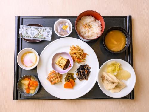 a tray with plates of food and bowls of food at Iga Ueno City Hotel in Iga