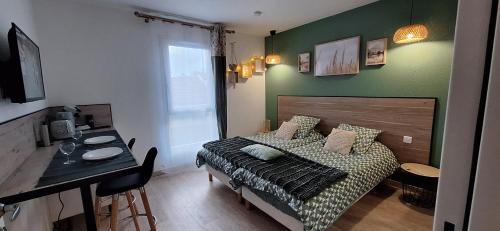 une chambre avec un lit, une table et un bureau dans l'établissement Charmant studio*le nature*, à Lourdes