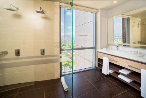 a bathroom with a tub and a sink and a window at Hilton Garden Inn Bogota Airport in Bogotá