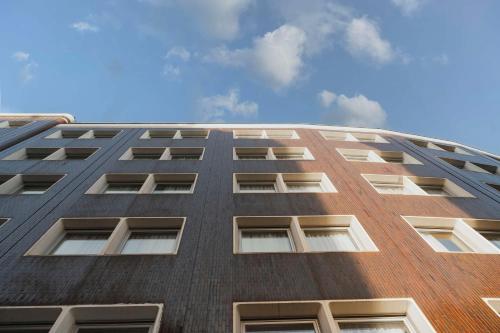 wysoki ceglany budynek z oknami przed niebieskim niebem w obiekcie Hilton Garden Inn Padova City Centre w Padwie