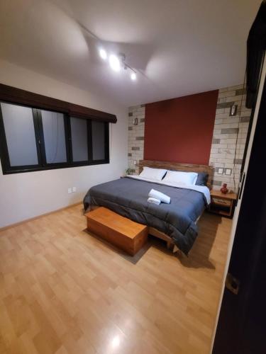 a bedroom with a large bed and a wooden floor at Casa B & L Céntrico Departamento in Oaxaca City