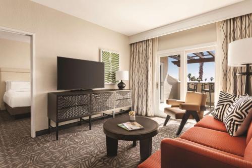 a hotel room with a television and a living room at Zachari Dunes on Mandalay Beach, Curio Collection by Hilton in Oxnard