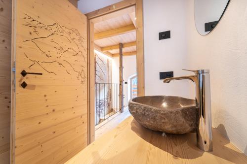 Mas del Mezdì - mountain chalet Val di Rabbi في رابي: حمام مع حوض حجري كبير في الغرفة