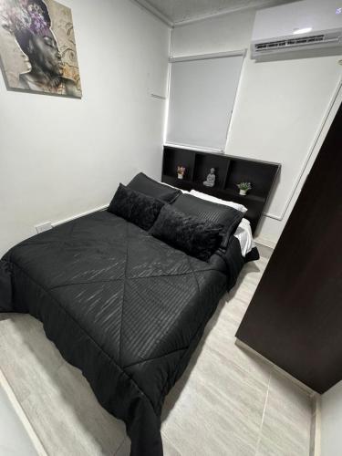 1 dormitorio con 1 cama negra en una habitación en Apartamentos todos con aire acondicionado, en Ibagué