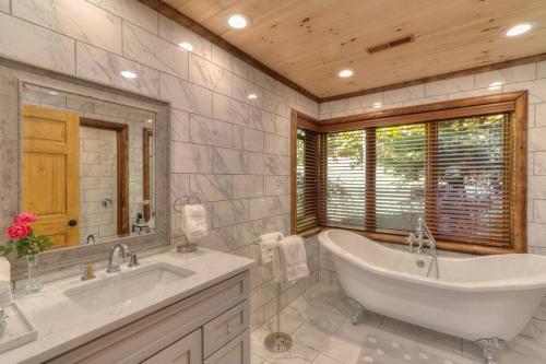 a bathroom with a tub and a sink and a mirror at Parkview Lodge In Gatlinburg in Gatlinburg
